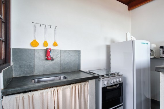 Cozinha completa do chalé com fogão, geladeira e utensílios