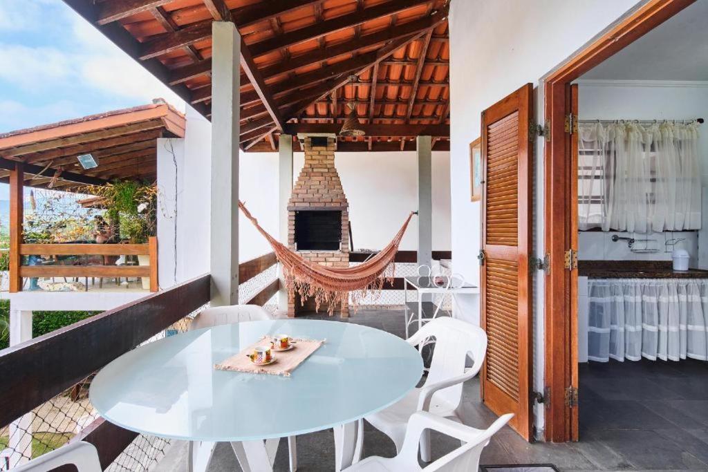 Varanda coberta com churrasqueira, rede e mesa para refeições