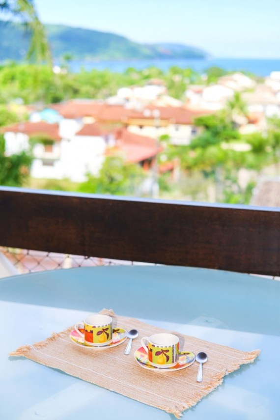 Café da manhã servido na hidromassagem com vista panorâmica para o mar e montanhas